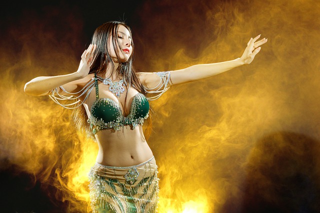 An Image Showcasing A Mesmerizing Belly Dancer, Gracefully Swaying Her Hips Adorned With Vibrant Coins And Delicate Tassels, Exuding Confidence And Power, As She Effortlessly Captivates The Audience With Her Fluid Movements