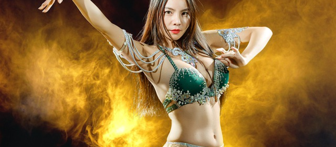 Rizing image capturing the essence of belly dance improvisation: a graceful dancer, adorned in vibrant silk veils, moving effortlessly to the rhythm of enchanting Middle Eastern music, embodying the flow of the melodies with fluidity and passion